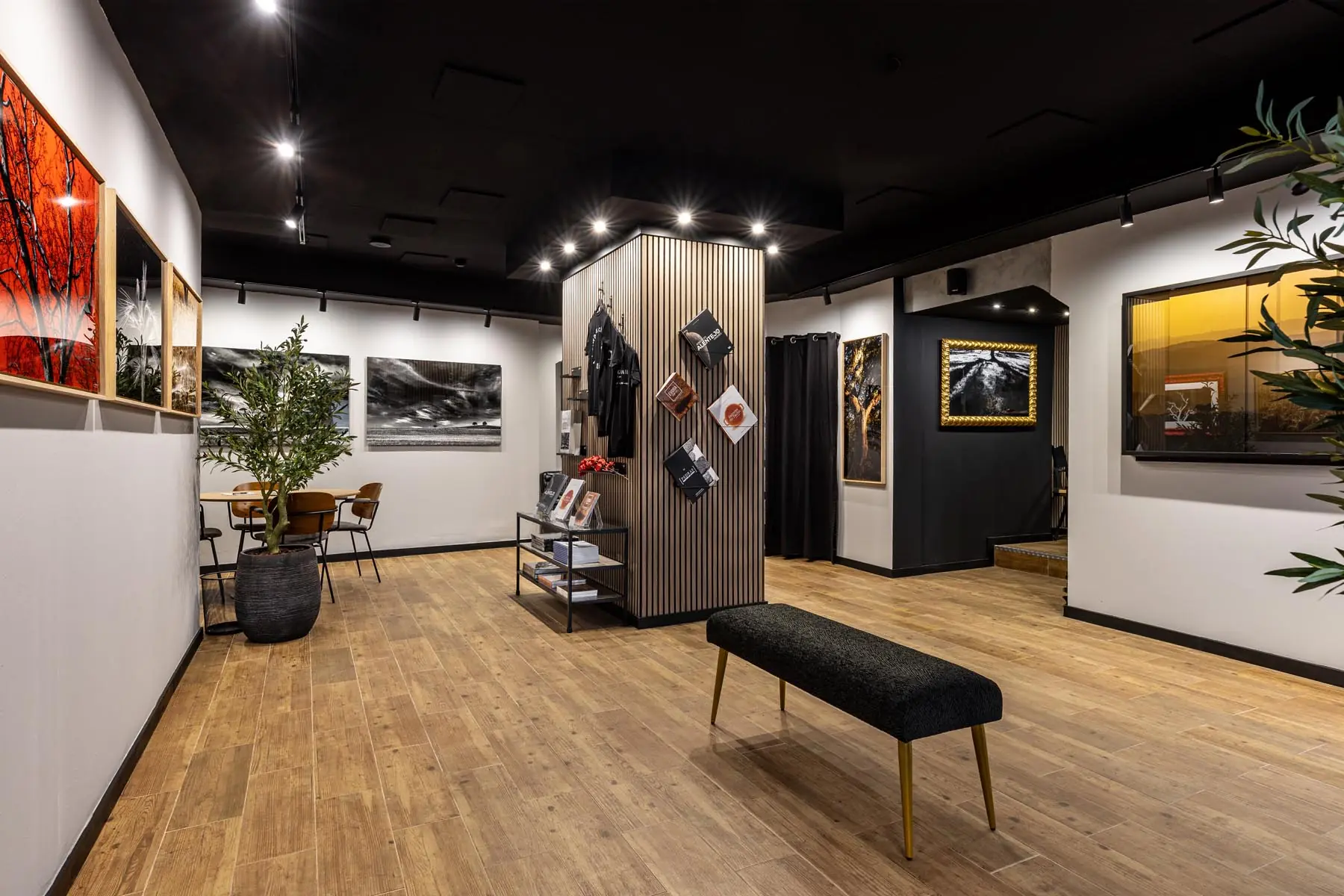 Sala principal da Galeria Visual Factory, com obras fotográficas nas paredes e expositor central.