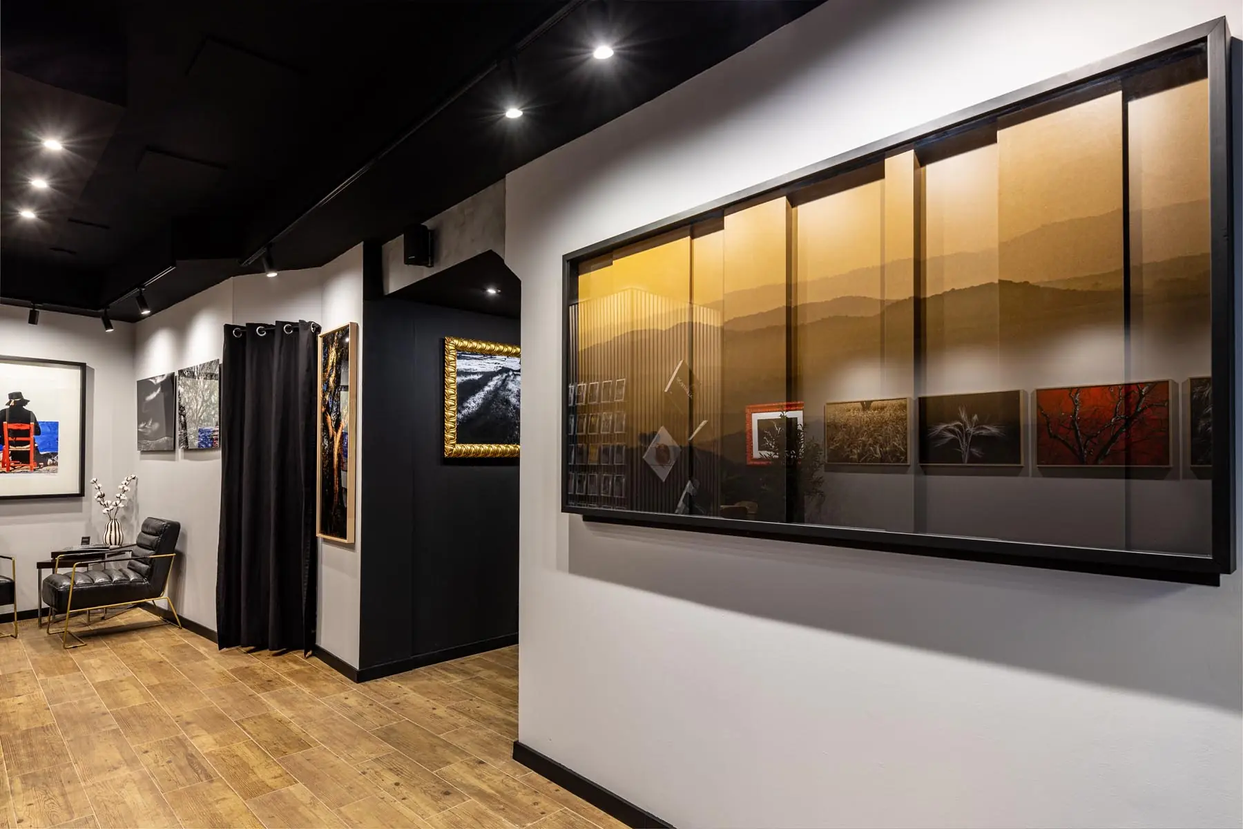 Obra panorâmica e fotografias emolduradas expostas na Galeria Visual Factory em Évora.